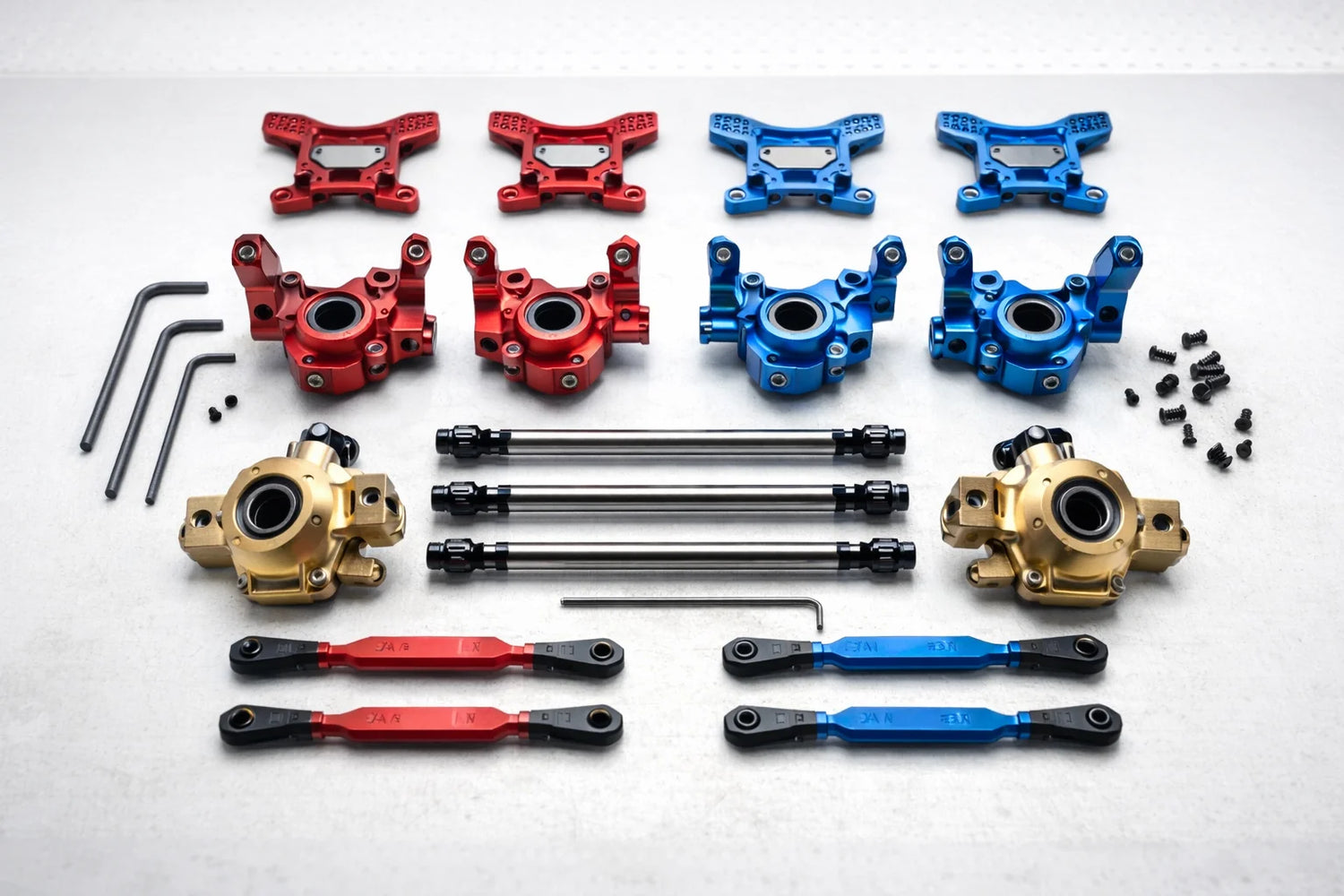 RC upgrade parts flat lay - red and blue aluminium knuckles, brass portals, CVD drive shafts